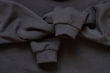 Fototapeta premium Sleeves tied in a knot on a black cotton sports sweater