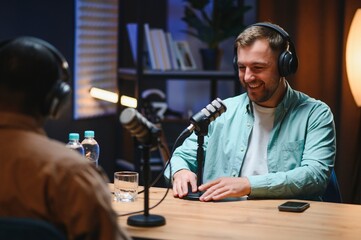 Man recording podcast using high tech microphones to interview guest, ensuring flawless video and...