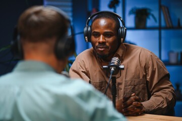 Man recording podcast using high tech microphones to interview guest, ensuring flawless video and...