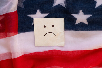 American flag and paper card with a drawing of emotions of resentment and sadness