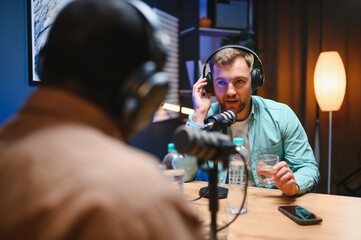 Man recording podcast using high tech microphones to interview guest, ensuring flawless video and sound quality for audience