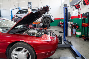 Fototapeta premium Car service workshop with cars on a column lifts