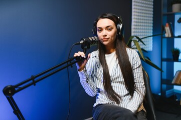woman records podcast, speaking into microphone
