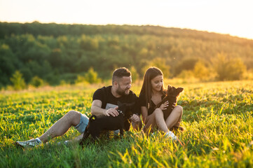 A cute little dog stands on its hind legs. A happy family plays together in the park with a...