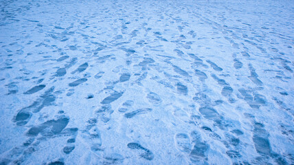 Tangled human footprints on snowy ice