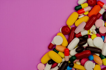 Assorted Colorful Pills and Capsules on Purple Background – Pharmaceutical Medication Concept