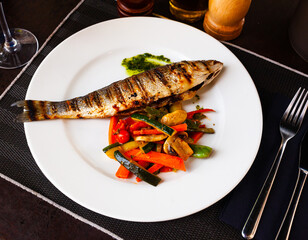 Delicious fish dish - baked sea bass with stewed vegetables. High quality photo
