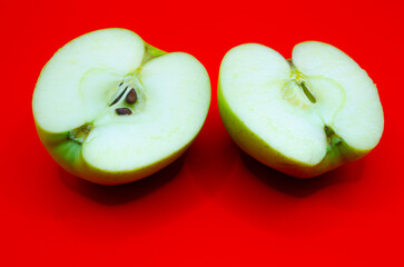 Sliced Green Apple on Red Background – Fresh and Juicy Fruit with Seeds