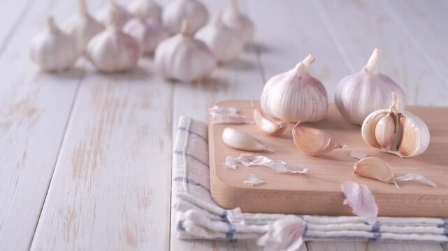 Raw whole garlic on a white wooden table. Garlic cloves and bulbs on a white wooden table, close up.