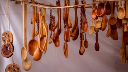 Handcrafted wooden spoons at an outdoor market. The unique carvings and natural wood tones...