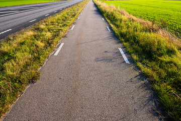 paved bicycle lane through open countryside.