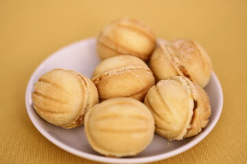 Fresh baked cookies on a sunny yellow table, great for cafe or bakery interiors.