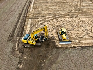 Luftaufnahme eines Baggers und Bulldozers bei der Arbeit auf einer Baustelle, Erdbau, Erdarbeiten,...
