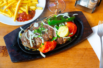 Traditional juicy grilled beef served with potatoes and vegetables in a cafe