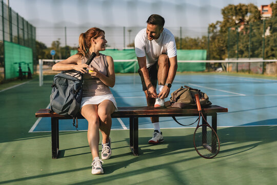 Young couple playing tennis outdoors enjoying a fun summer game