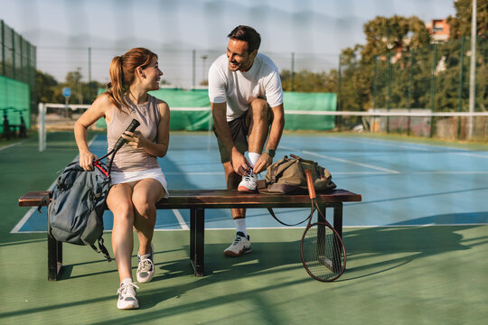 Young couple playing tennis outdoors enjoying a fun summer game