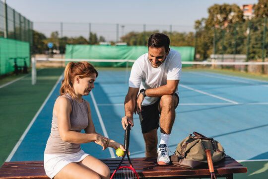 Young couple playing tennis outdoors enjoying a fun summer game