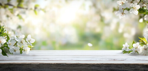 Spring background with white blossoms and white wooden table. Spring apple garden on the background 
