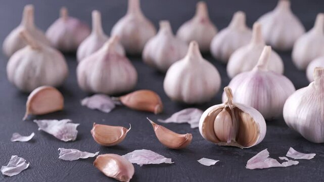 garlic on a black stone table.
organic garlic bulbs on a black table.
