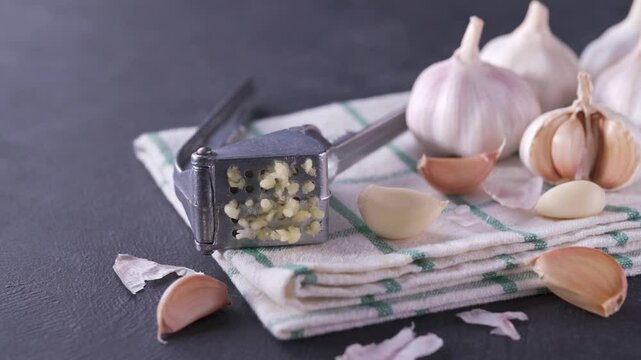 Close-up of garlic bulbs on a black stone table with garlic blur background. Peeled garlic bulbs on a black table.