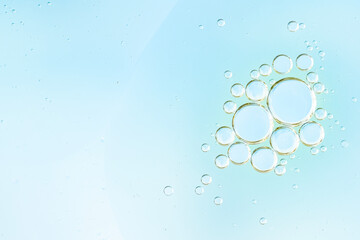 Transparent water bubbles rising in a soft blue liquid background. Refreshing, clean photo perfect for themes of purity, hydration, and freshness. Cosmetic advertising and scientific illustration. 