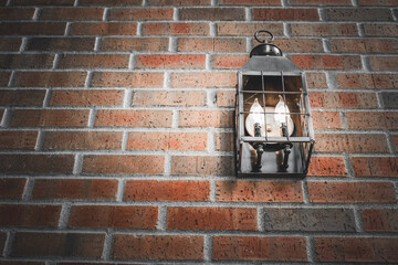 close-up of a rustic sconce lantern on a brick wall architectural detail with space for copy