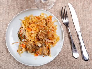Appetizing stewed pork ribs served on platter with cabbage..