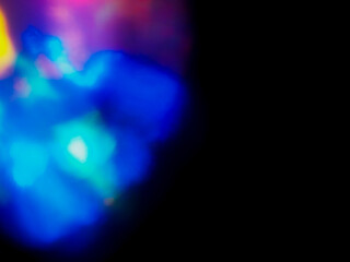 A colorful, blurry background with a rainbow of colors. The colors are bright and vibrant, creating a sense of energy and excitement. Abstract design wall paper. Cinematic light effect.