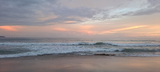 Fototapeta premium O anoitecer em um dia parcialmente nublado na praia do Félix, em Ubatuba, litoral norte paulista, Brasil.