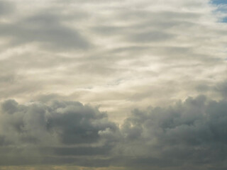 The sky is cloudy and the sun is shining through the clouds. The sky is blue and the clouds are white