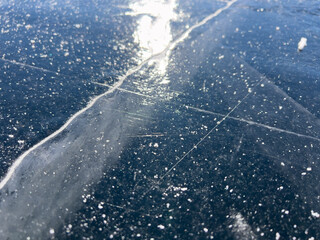 A close-up view of a frozen surface with visible cracks and bubbles, capturing the intricate details and natural patterns of the ice.