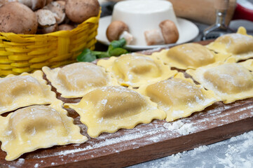 Italian food, fresh home made stuffed pasta ravioli dumplings with ricotta soft cheese and champignons porcini mushrooms, Parma, Emilia Romagna, Italy