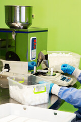 Research assistant fills jars with pills, medicines on automatic pharmaceutical equipment. Production and manufacturing of medical preparations.	