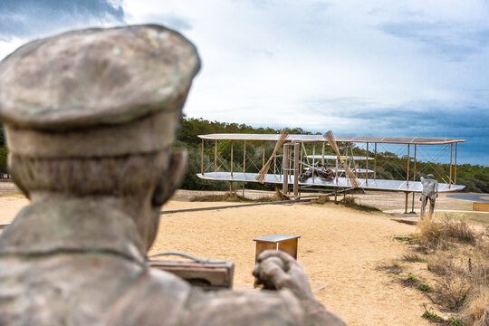 Kitty Hawk, NC - USA: Sculpture of Wright Brothers First Flight famous photograph showing the back of the photographer and camera in foreground and the Wright Flyer in background