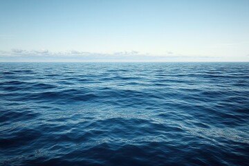 Obraz premium Vast blue ocean waves under clear sky creates a serene coastal atmosphere