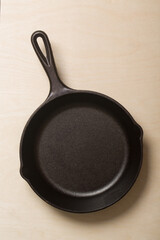 Black cast iron skillet on a birch wood panel kitchen countertop
