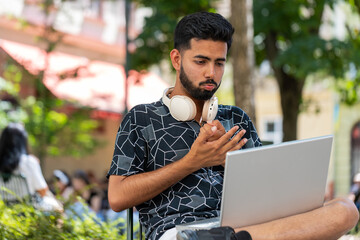 Hispanic young man using laptop computer typing browsing, loses becoming surprised sudden lottery...