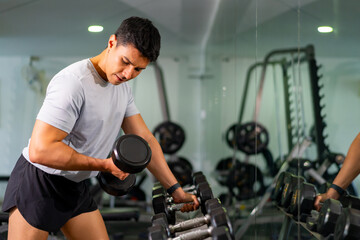 Healthy Asian man athlete do sport training workout exercise weight lifting dumbbell at fitness...