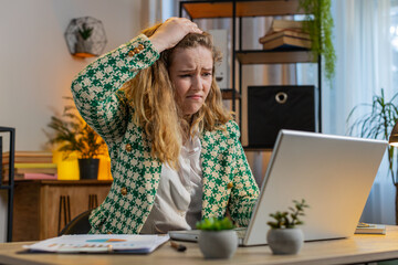 Displeased sad woman using laptop notebook typing browsing working loses becoming surprised sudden...