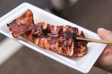 Ikayaki, Grilled roasted Squid with sauce - popular Japanese Street Food, variety of different traditional food snack selection in Tokyo, Japan, street market with local vendor stalls cooking