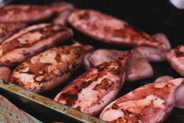 Ikayaki, Grilled roasted Squid with sauce - popular Japanese Street Food, variety of different traditional food snack selection in Tokyo, Japan, street market with local vendor stalls cooking