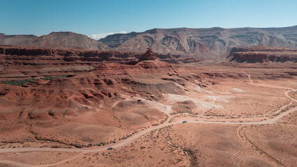 Drone view of a road in the middle of a desert environment, cars on the road