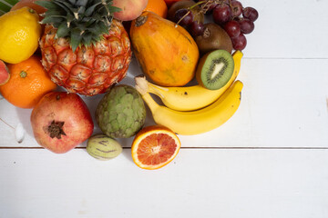 Summer mix of tropical fruits over white wooden background