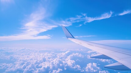 Fototapeta premium Wing of aircraft soaring above fluffy clouds. Ideal for travel, aviation, vacation, and freedom-themed visuals.