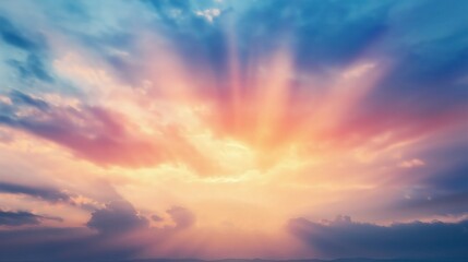 Sun rays breaking through dramatic colorful sky with soft clouds