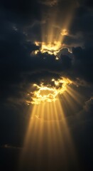 Obraz premium Majestic sunbeams breaking through dramatic clouds at sunset