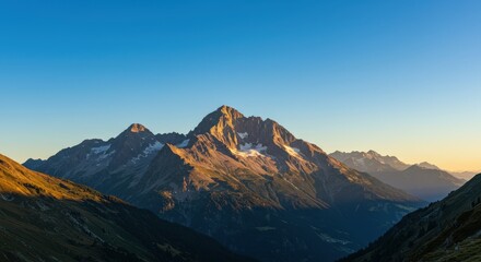 Majestic mountain range at golden hour with clear blue sky in scenic alpine landscape