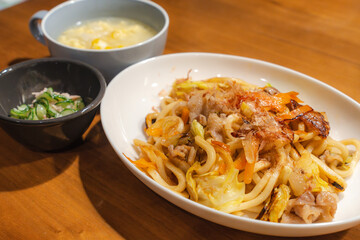 焼きうどんと卵スープの家庭的な食卓
