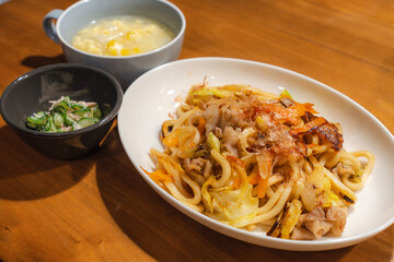 焼きうどんと卵スープの家庭的な食卓