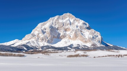 Snowy mountain peak, winter landscape, snow-covered valley, clear blue sky, scenic view